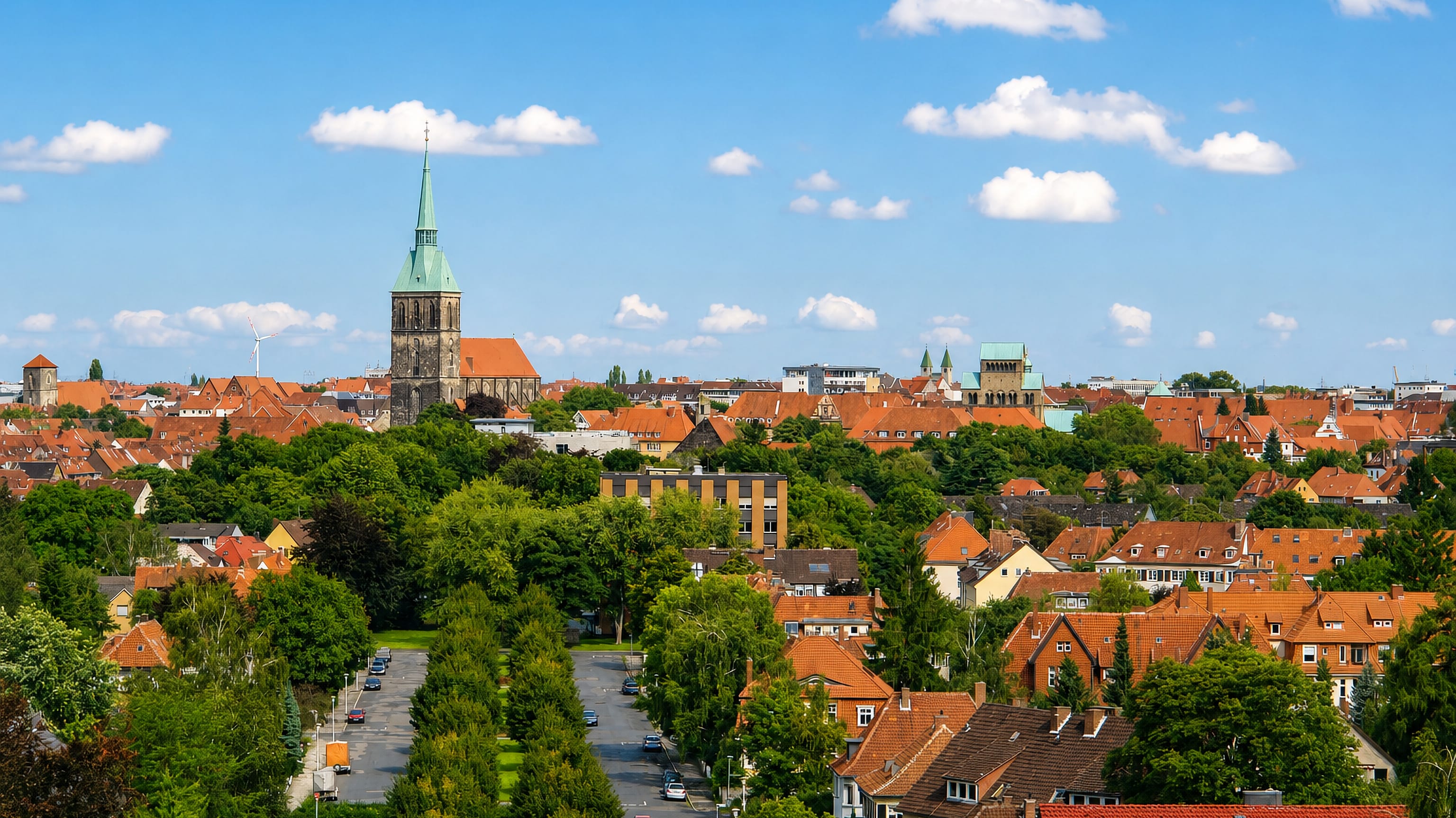 Hildesheim rooftops with the green spire of St Andreas church and the Romanesque cathedral westwork beyond