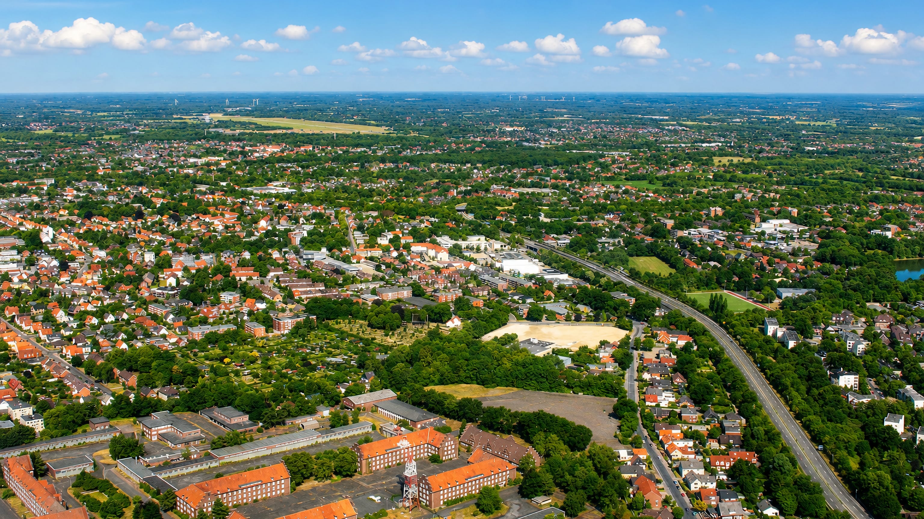 Aerial view over Donnerschwee in Oldenburg, a large red-brick barracks complex among red-roofed streets.