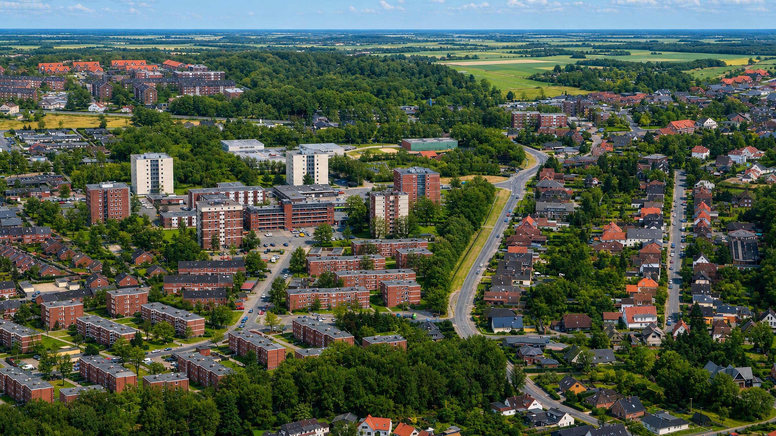 Aerial view of apartment blocks and red-roofed houses backed by open farmland in Aldenburg, Wilhelmshaven.