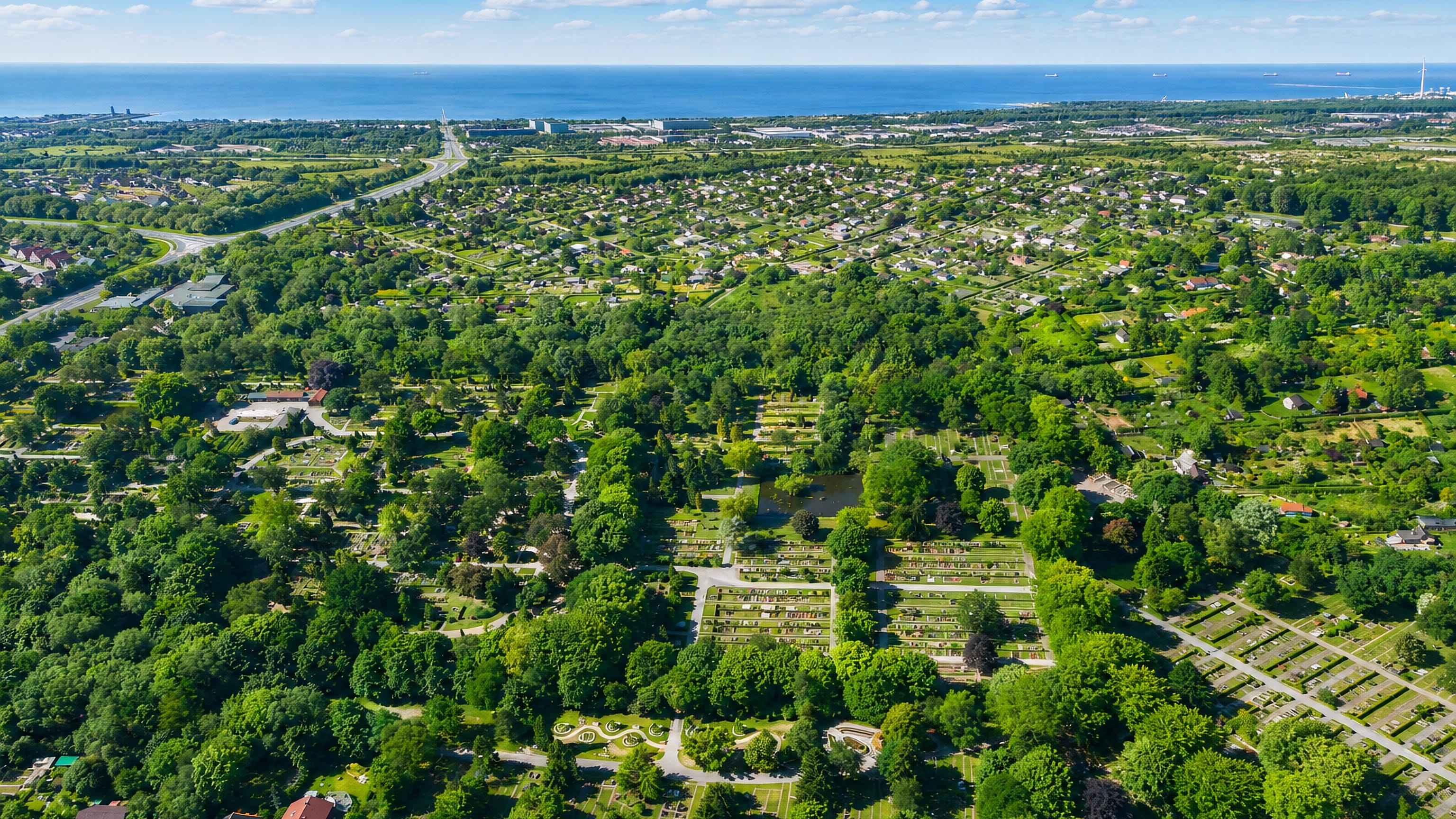Aerial view of Neuengroden in Wilhelmshaven, with wooded cemetery grounds and allotments reaching to the Jade Bight.