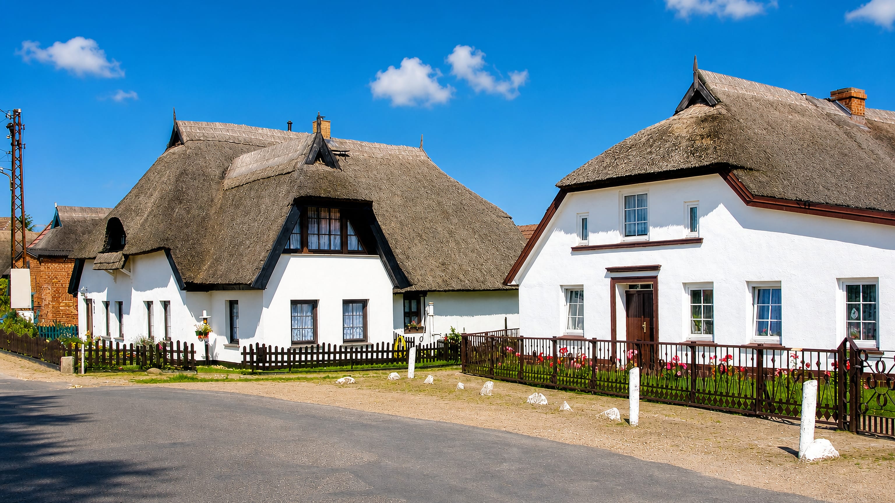 Thatched white cottages along a quiet street in Wieck, the fishing village quarter of Greifswald.