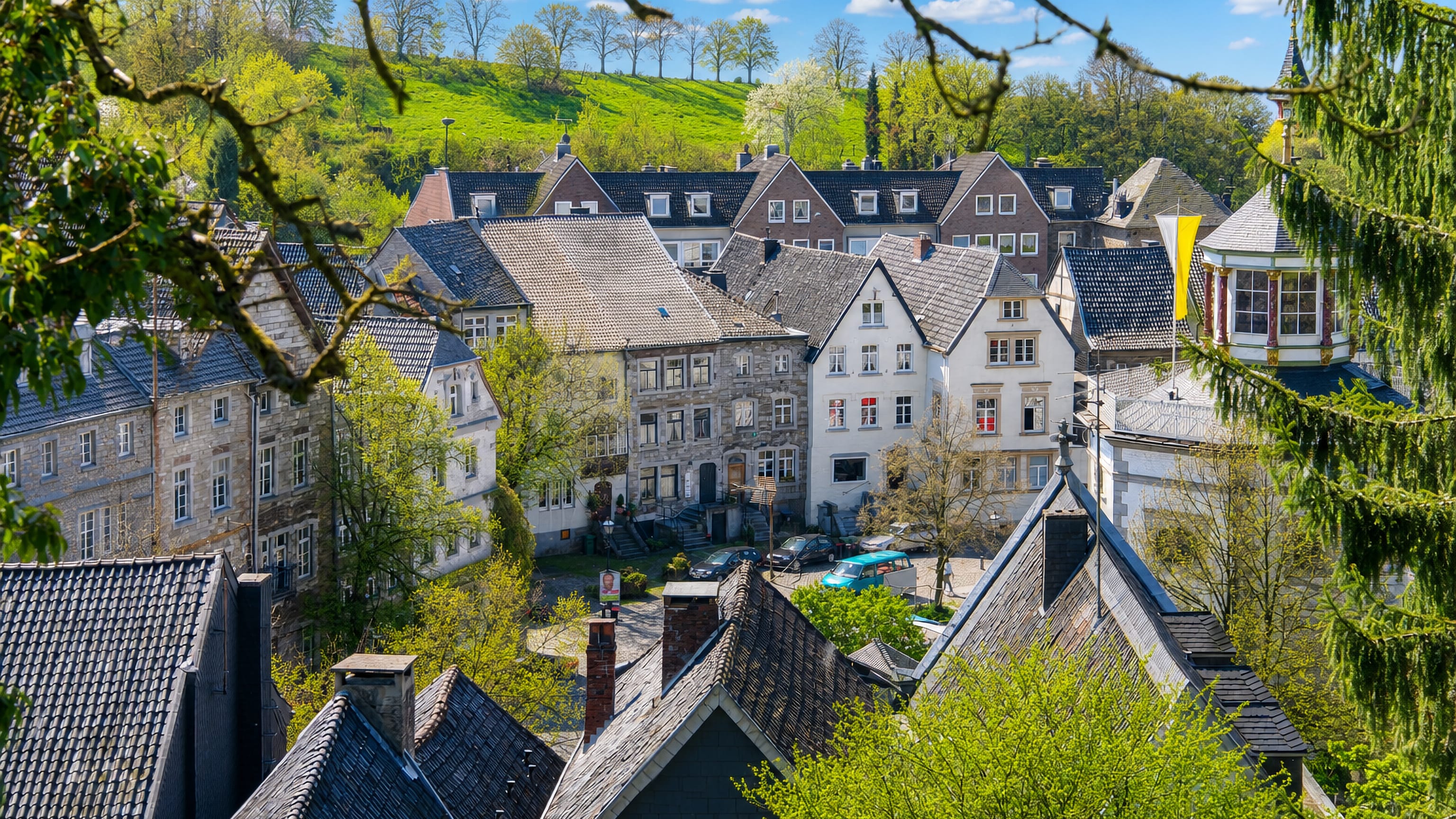 Historic slate-roofed houses of Kornelimuenster village in Aachen amid green hills