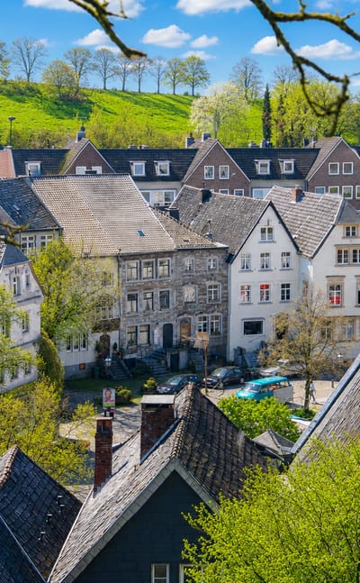 Historic slate-roofed houses of Kornelimuenster village in Aachen amid green hills
