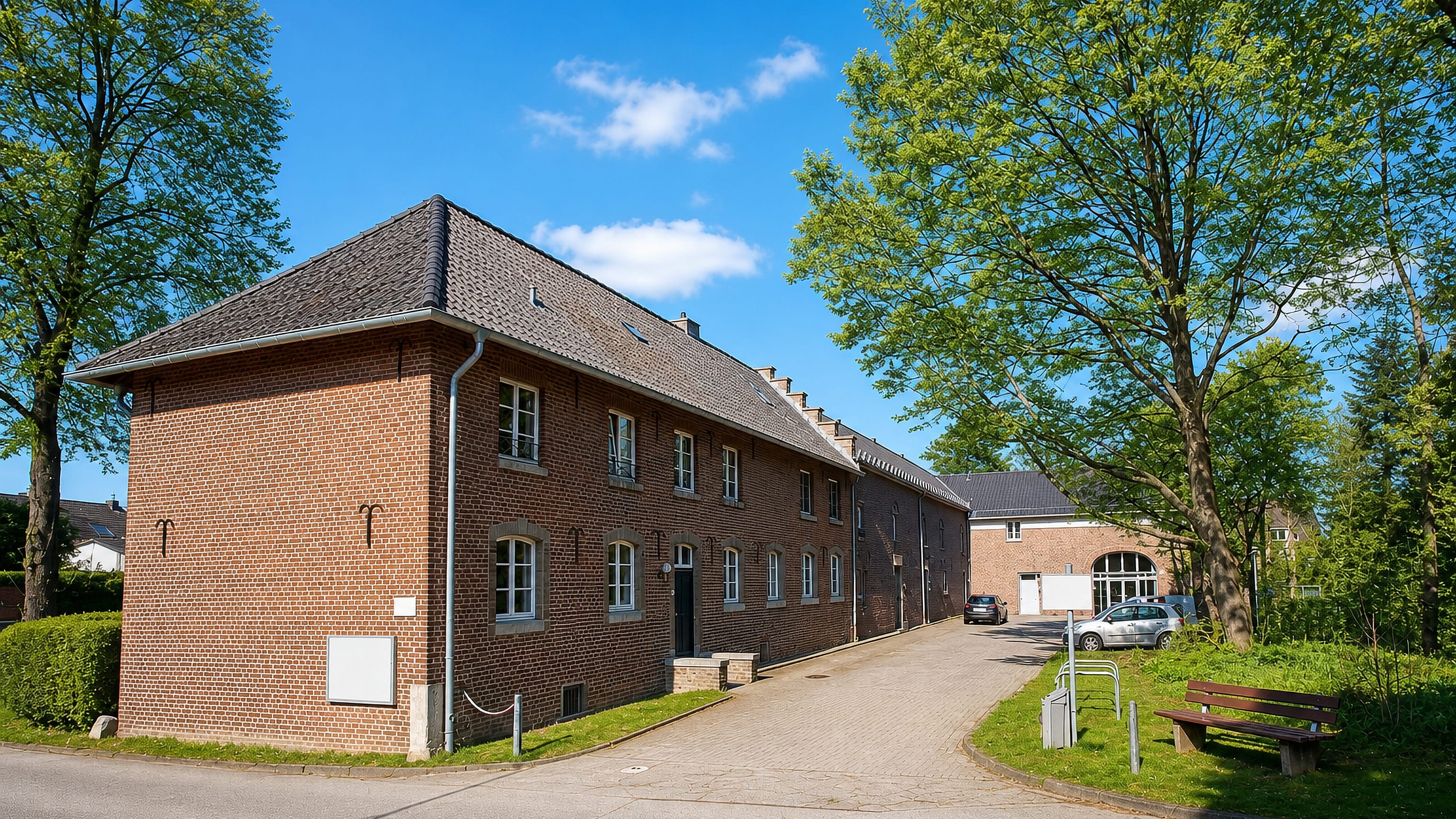 A brick manor building and quiet lane in Richterich, a village-like borough on the edge of Aachen.