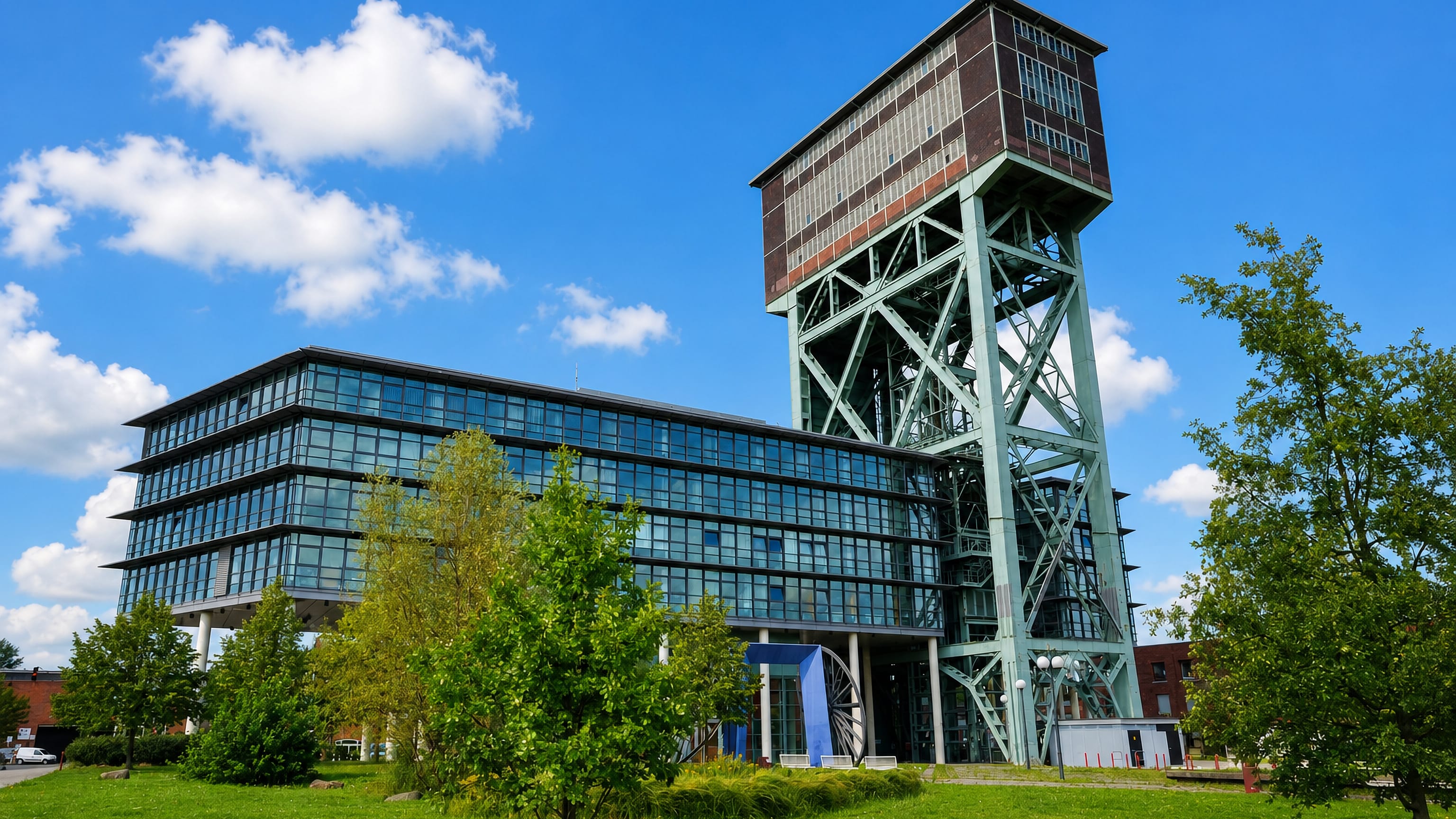 The Hammerkopfturm winding tower of the former Minister Stein colliery beside a glass office in Dortmund-Eving.