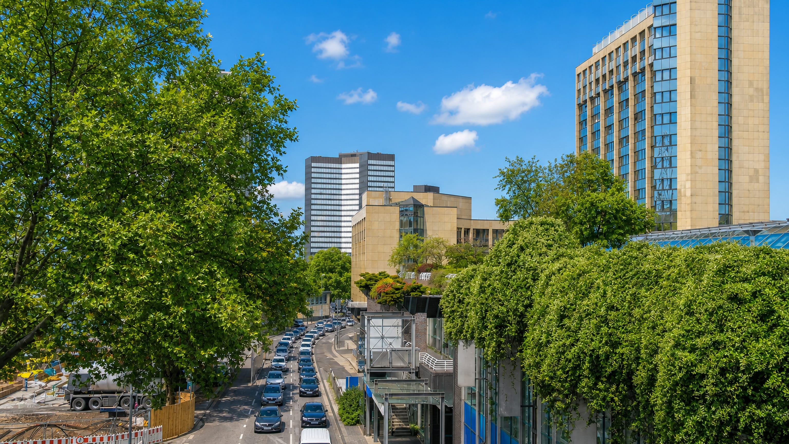 Tree-lined boulevard with traffic and post-war office towers in Stadtkern, Essen's city centre.