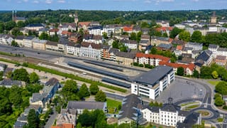 Iserlohn, North Rhine-Westphalia, over the railway station and square toward church towers and wooded hills.