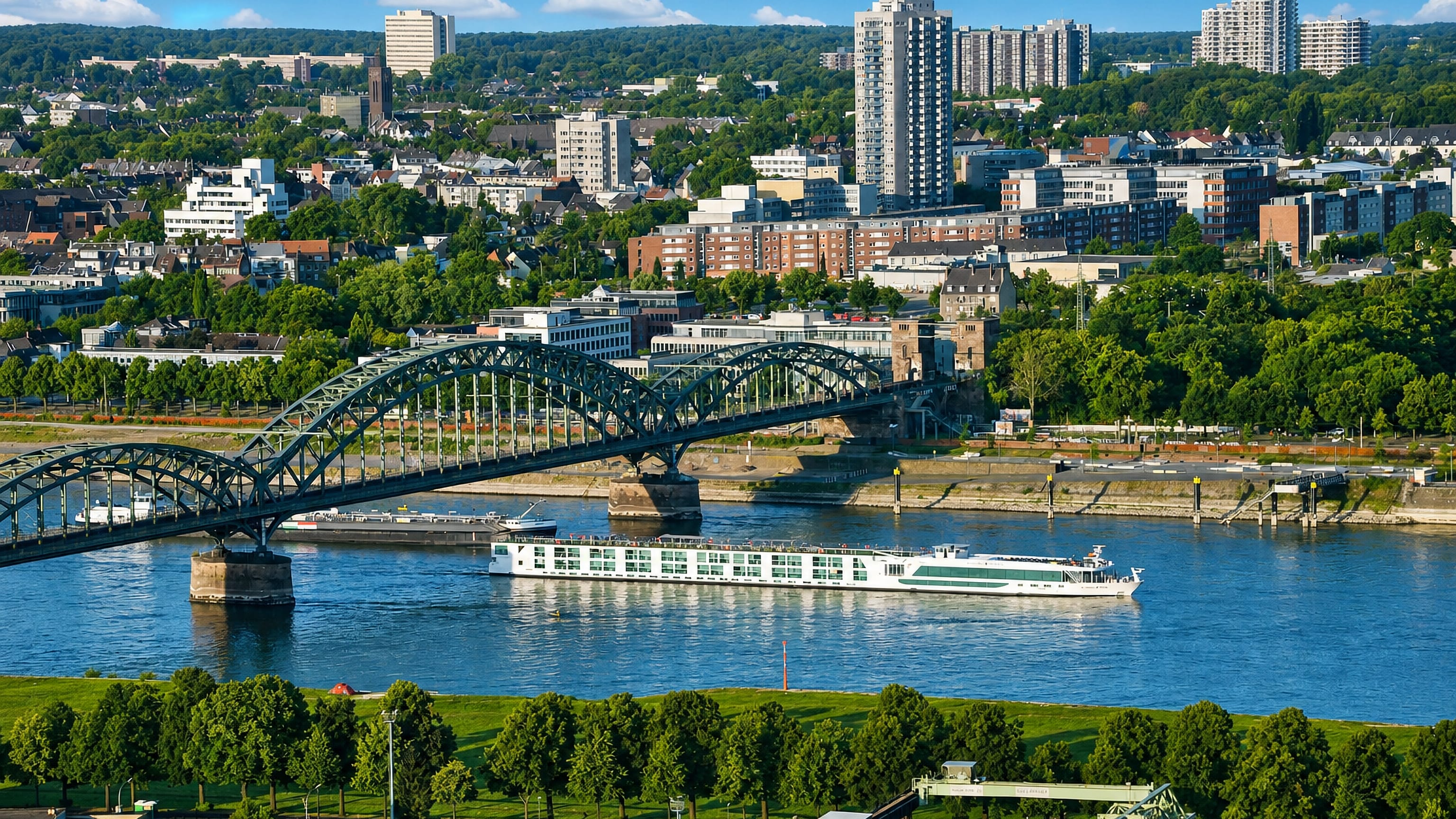Steel arch of the Südbrücke over the Rhine with a river cruiser passing Bayenthal in Cologne