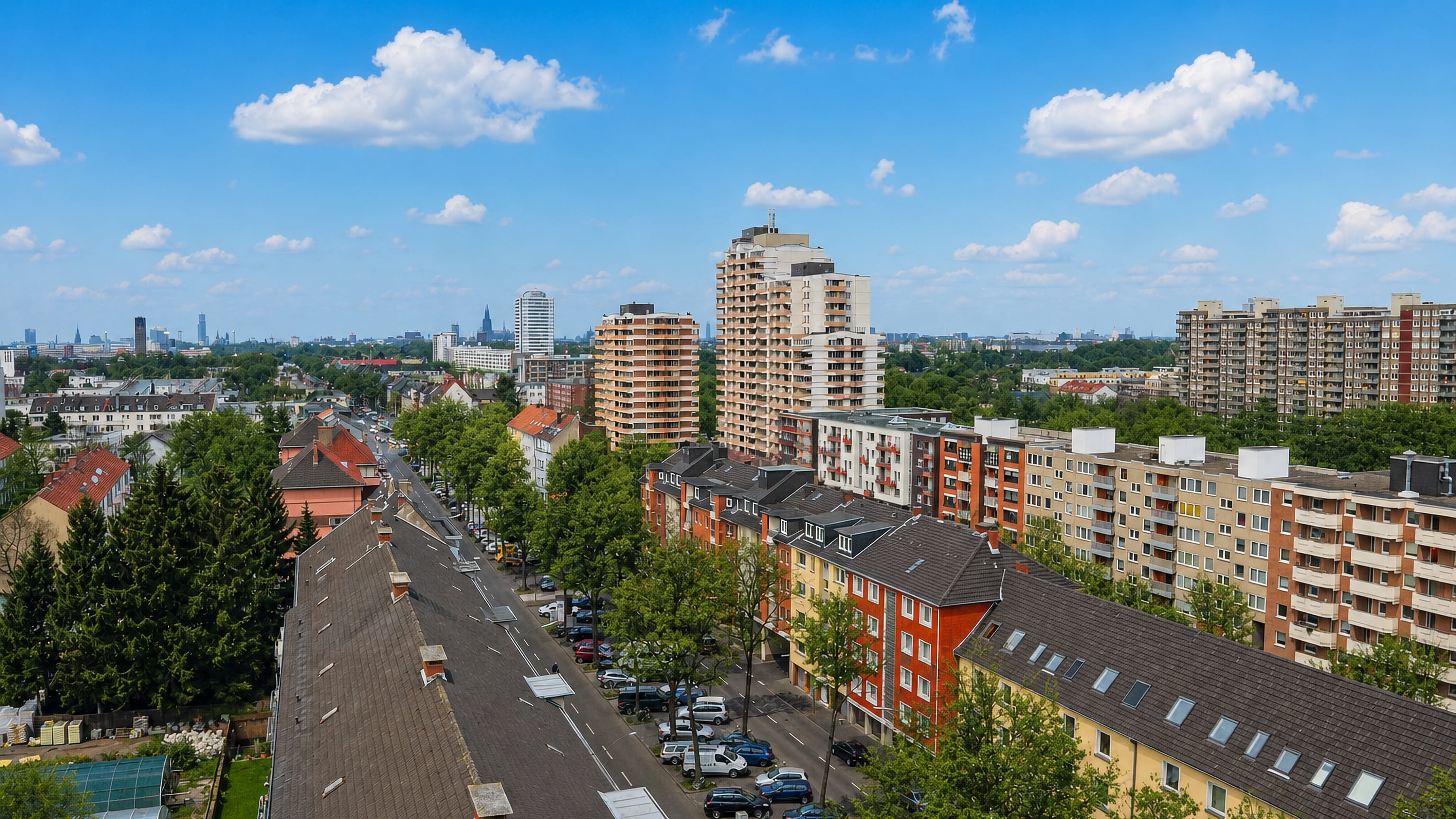 Aerial view over Zollstock's residential streets and apartment blocks in Cologne, with the city skyline beyond