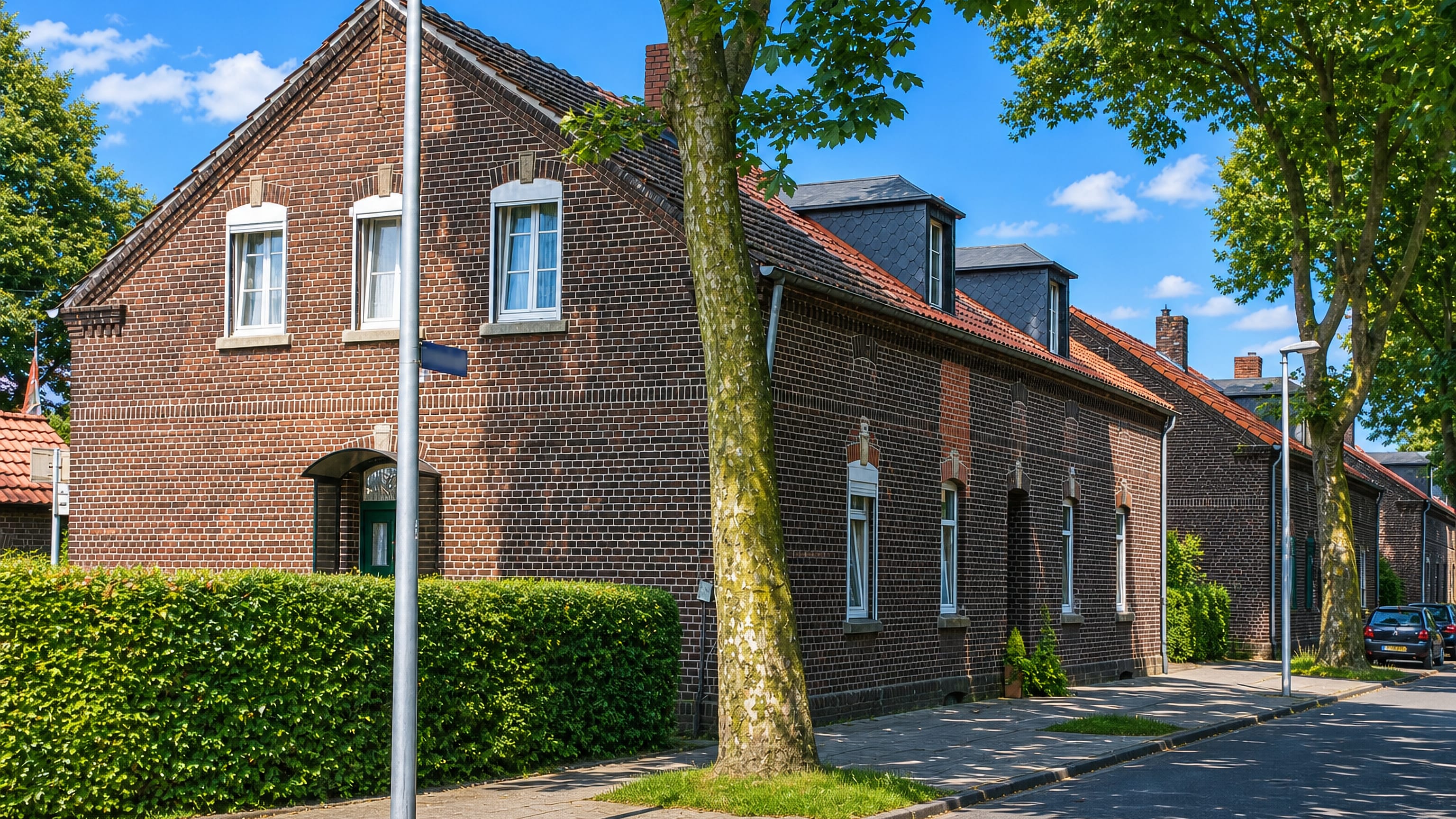 Brick terraced workers' housing along a tree-lined street in Dunkelschlag, Oberhausen.