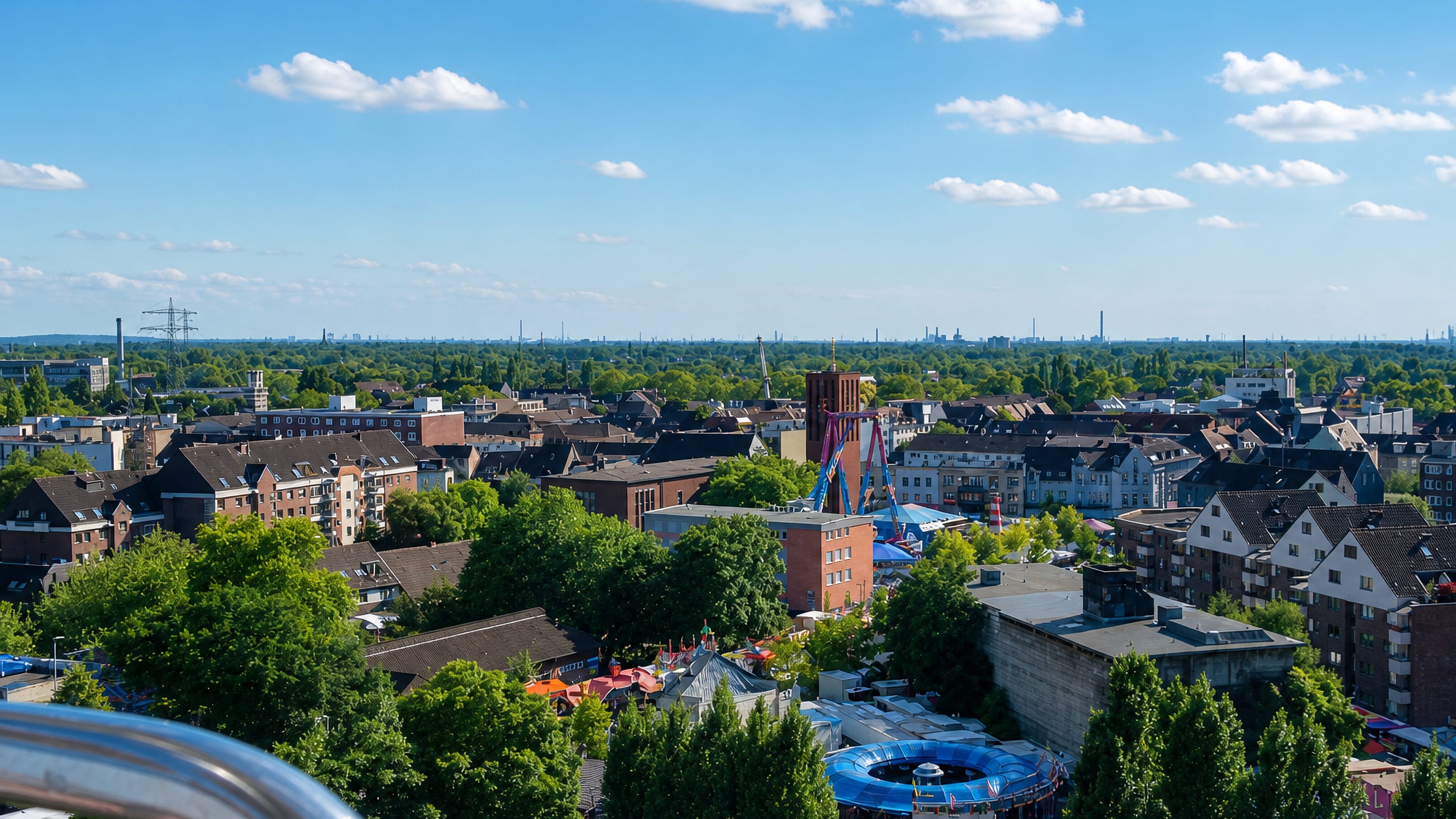 Rooftops of Sterkrade in Oberhausen seen over its funfair, with Ruhr industry on the horizon.