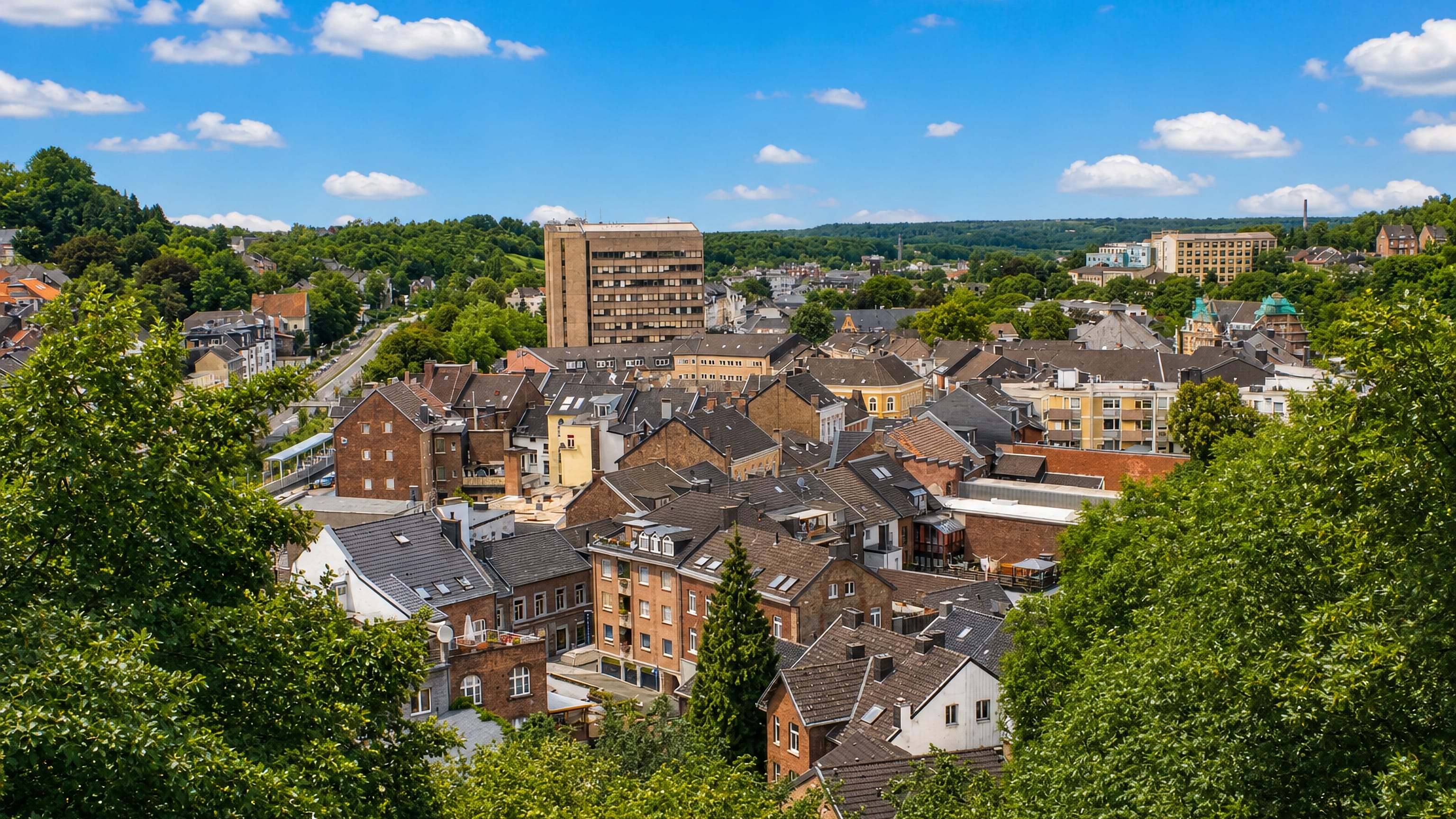 Stolberg in North Rhine-Westphalia, slate and brick rooftops filling a wooded valley below green hills