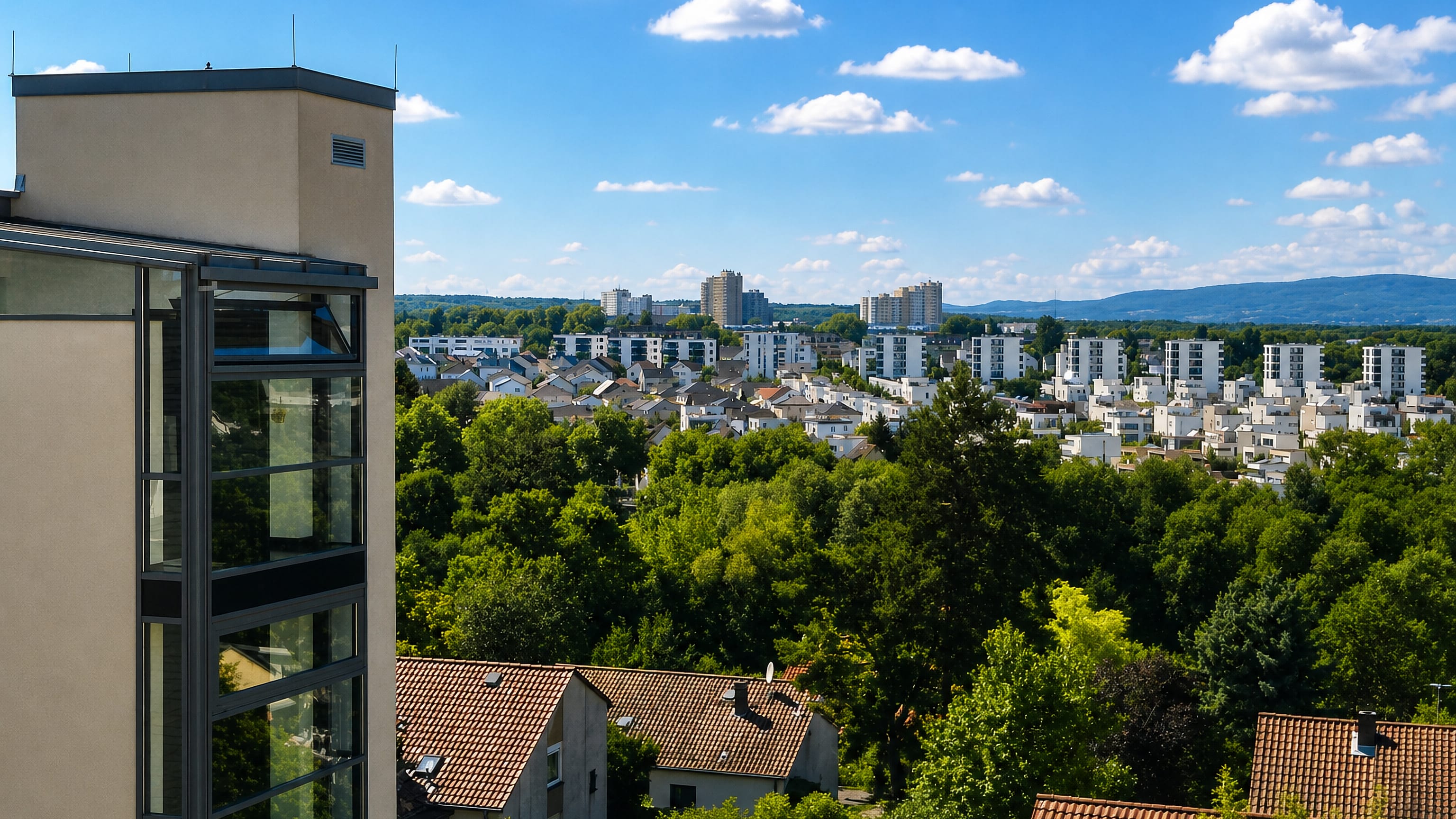 Leafy Gonsenheim in Mainz seen from a tower block, with white housing estates and the Taunus hills beyond.