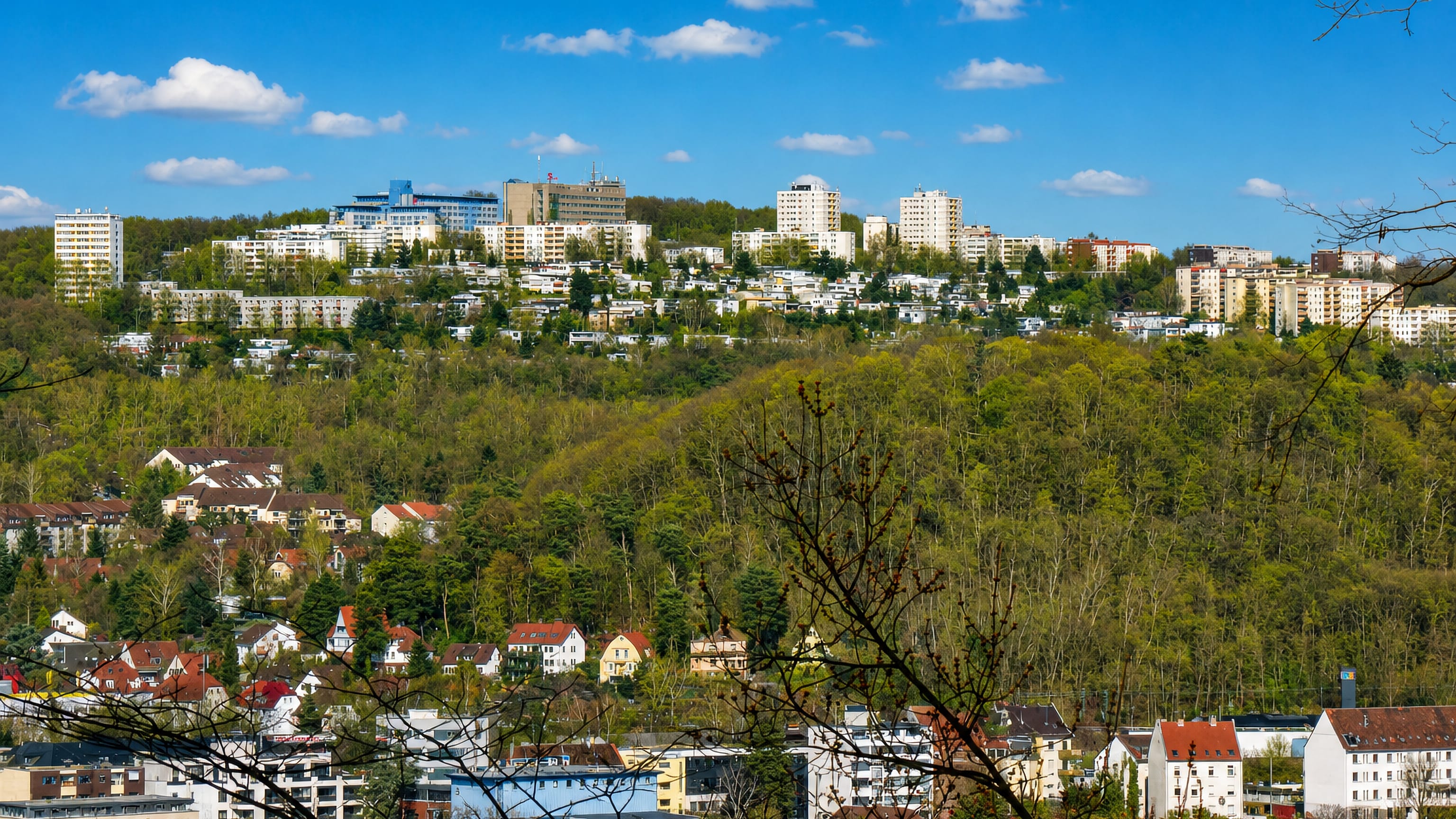 The hilltop housing estate of Eschberg rising above wooded slopes and the valley suburbs of Saarbrücken.