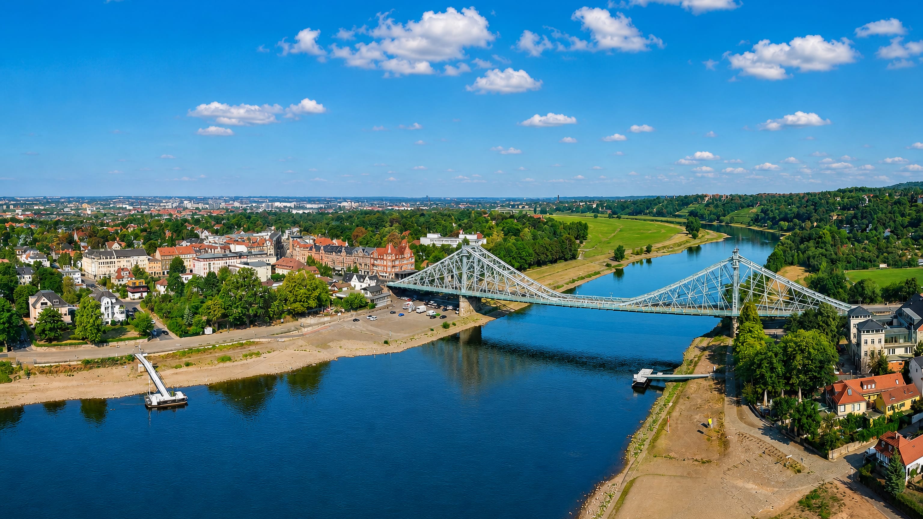 The Blue Wonder bridge crossing the Elbe at Blasewitz, Dresden, with riverside villas and green meadows.