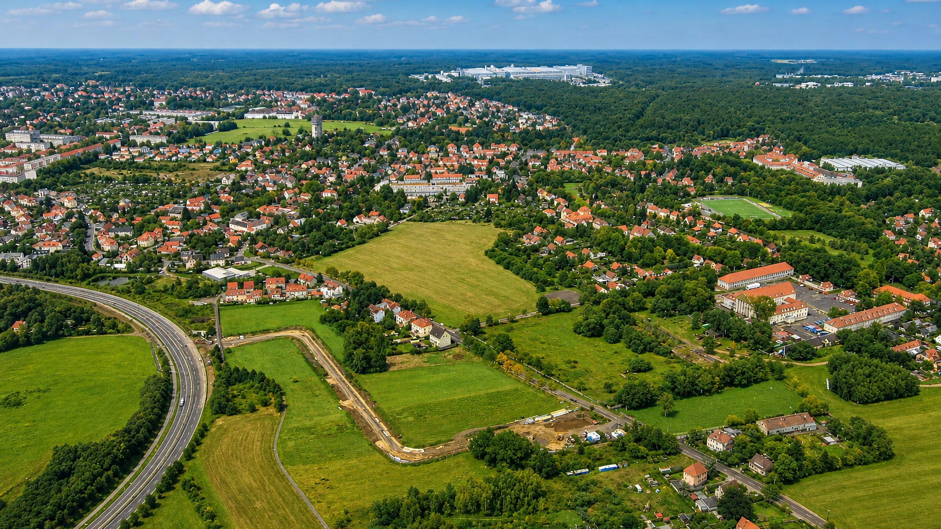 Aerial view of red-roofed houses, woodland and the autobahn at Klotzsche in northern Dresden.