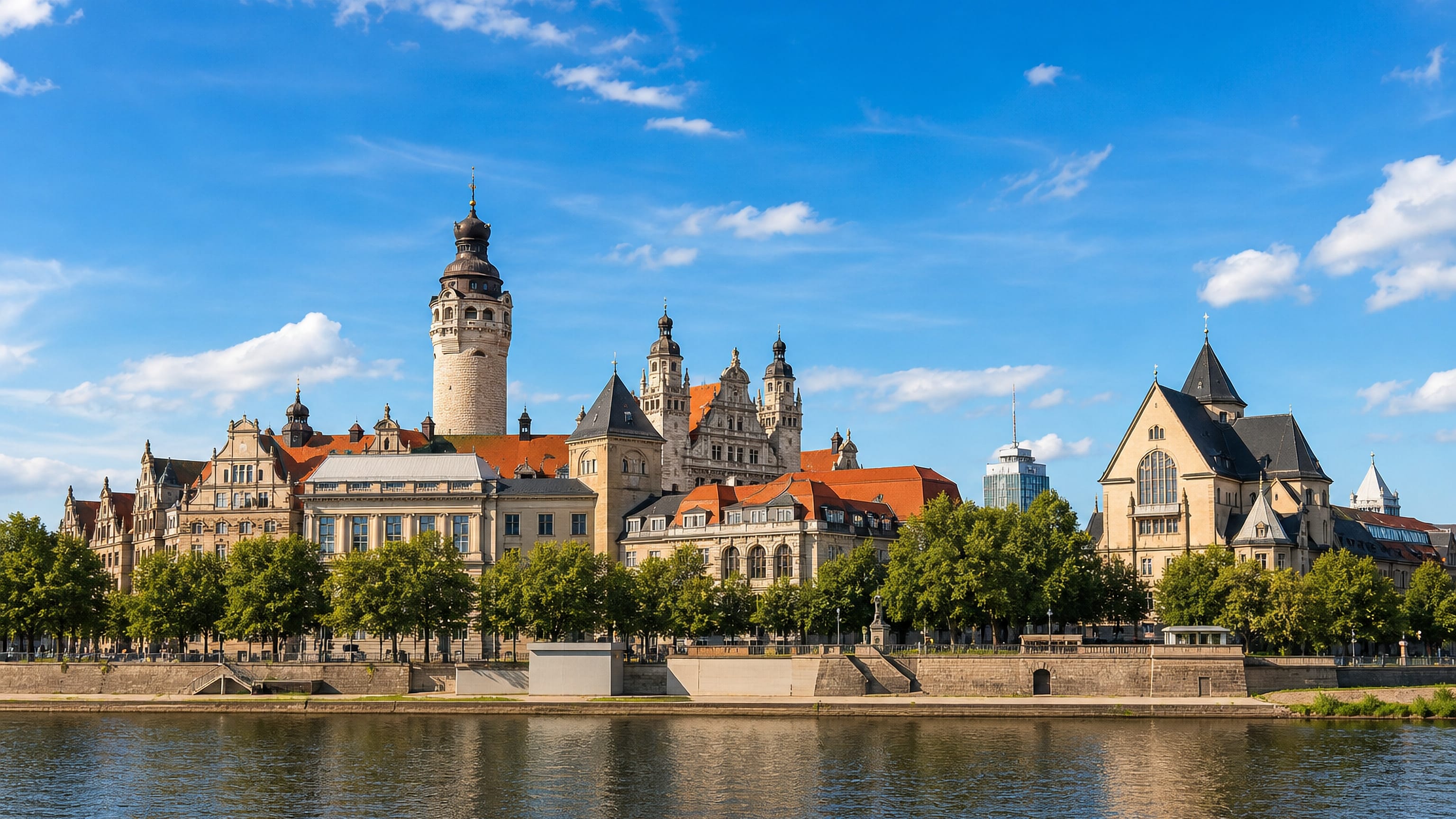 Central Leipzig's New Town Hall tower rising above tree-lined waterfront buildings near Probstheida