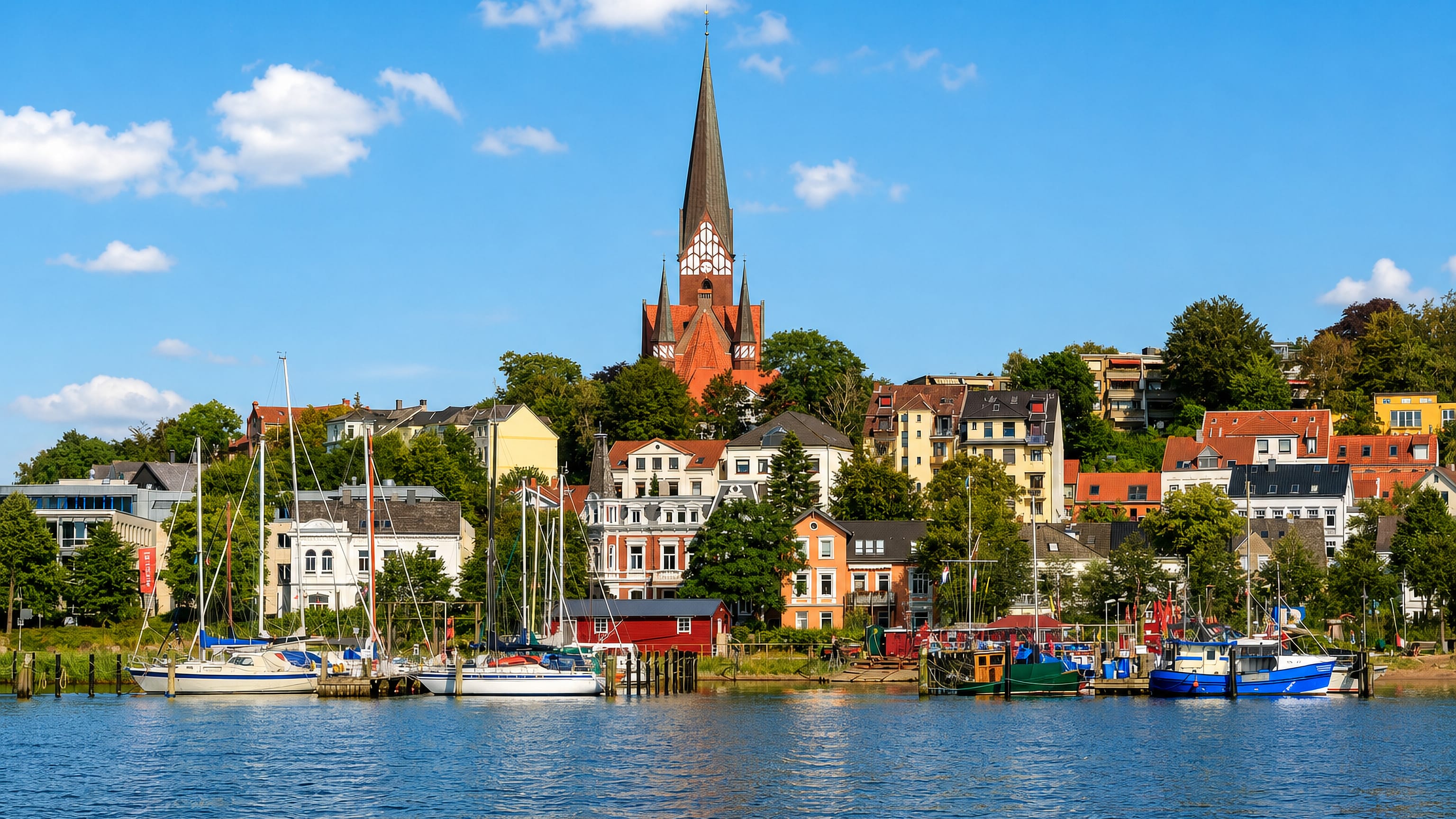 St Jürgen church above the harbour houses and moored sailboats of Jürgensby, Flensburg.