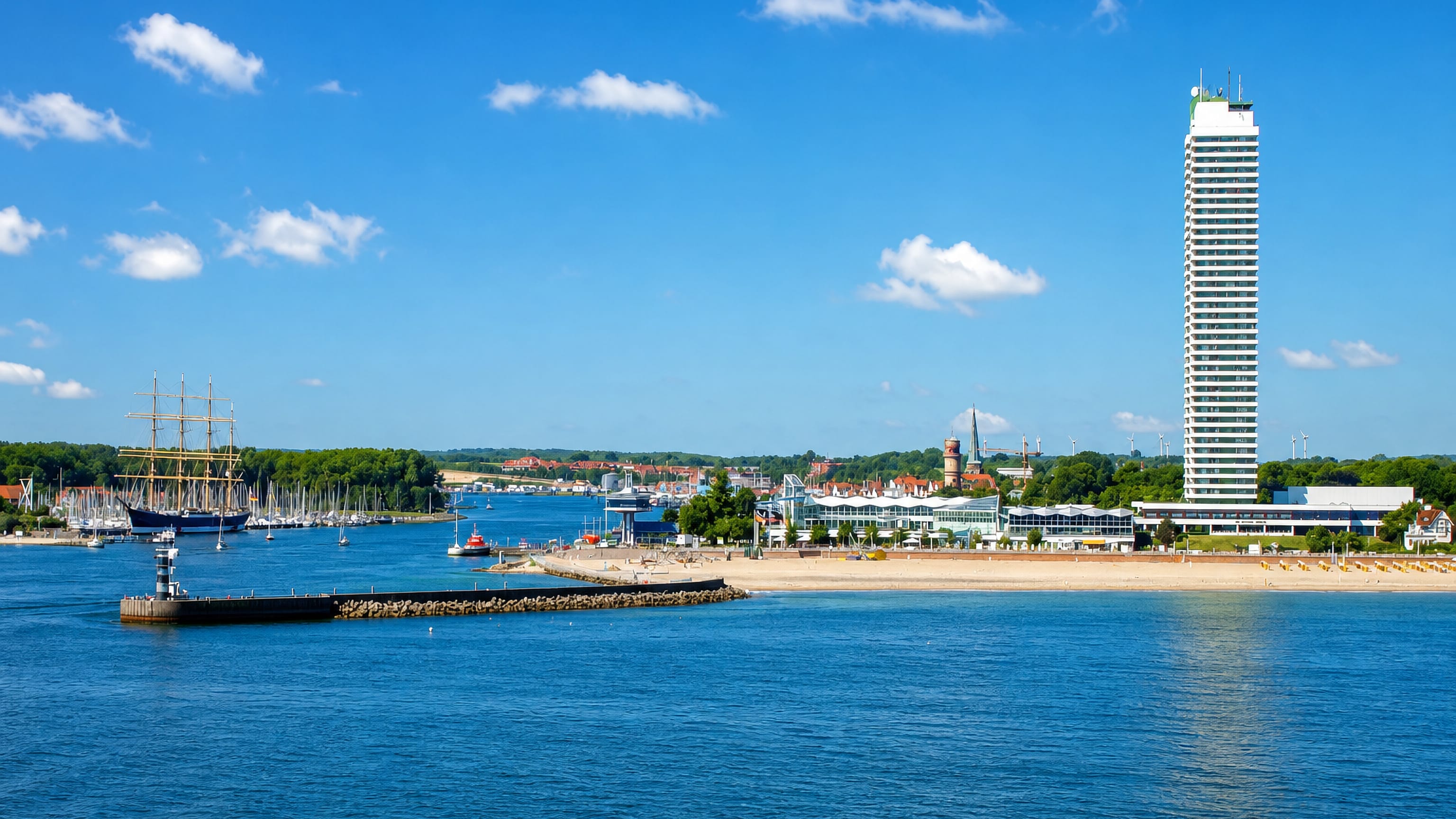 Travemünde, Germany, seen from the Trave mouth with its beach, Maritim tower and the Passat sailing ship.