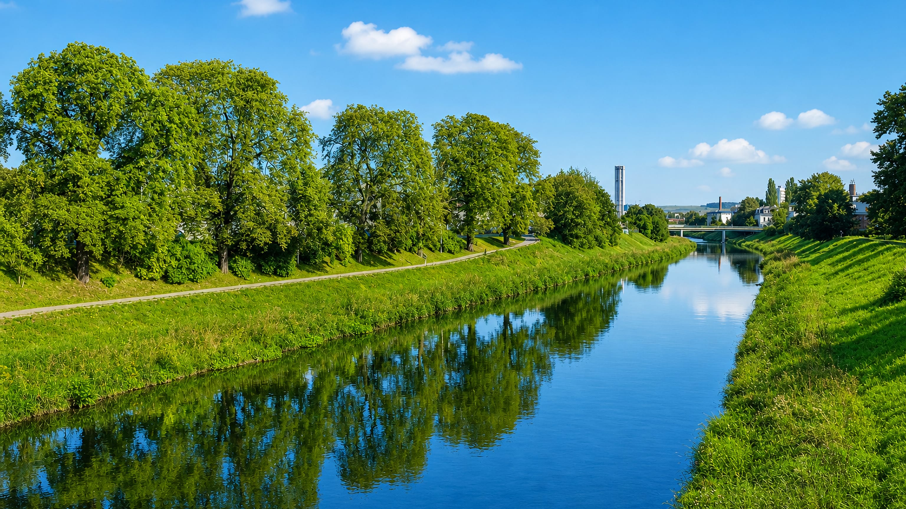 The Weisse Elster river curving between tree-lined green banks on the edge of Gera, Thuringia
