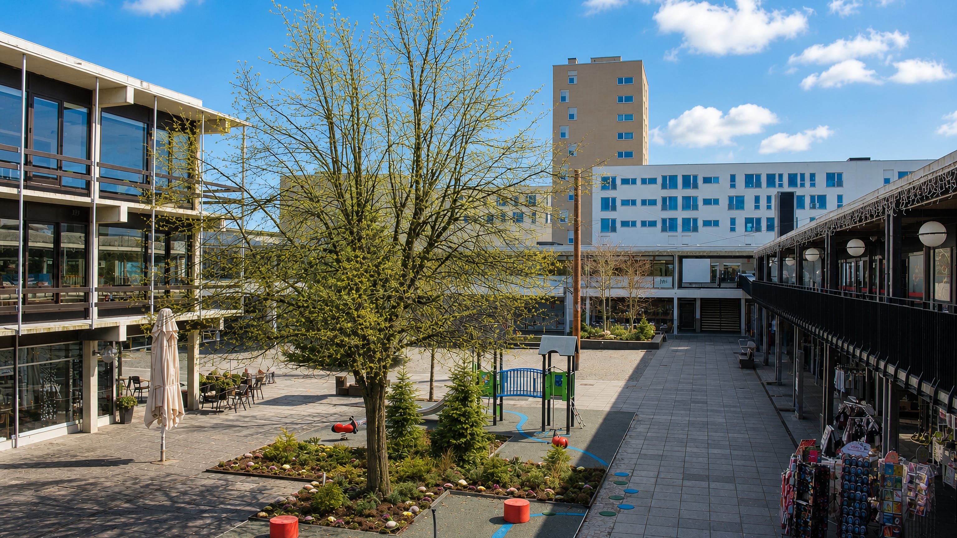 Albertslund's modernist pedestrian town centre in Denmark, with playground, planted square and tower block