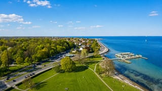Aerial of Charlottenlund's coastal park, shoreline road and harbour pavilion on the Øresund
