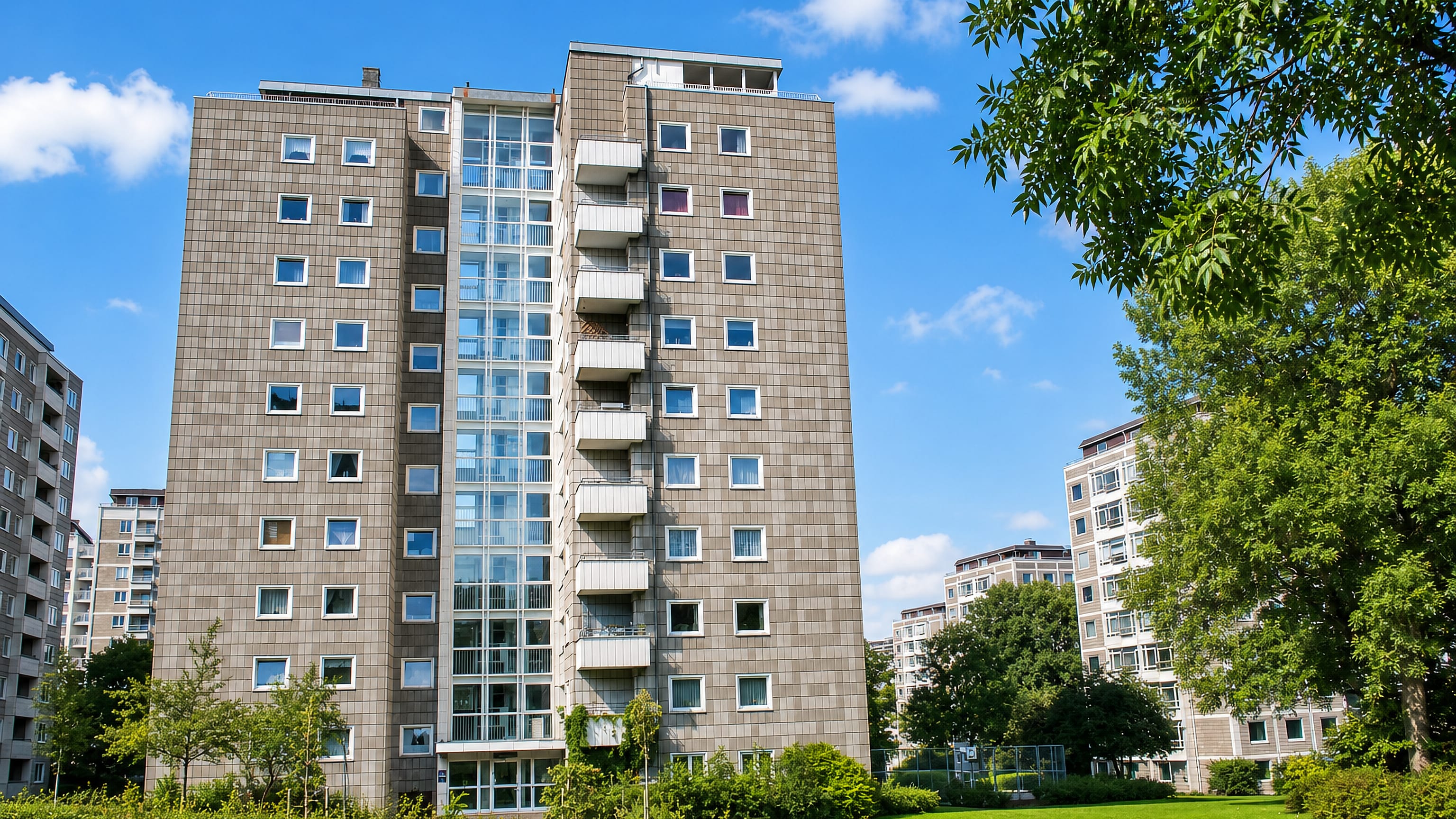 Tile-clad high-rise housing tower set in lawns and trees at Bellahøj, Copenhagen.