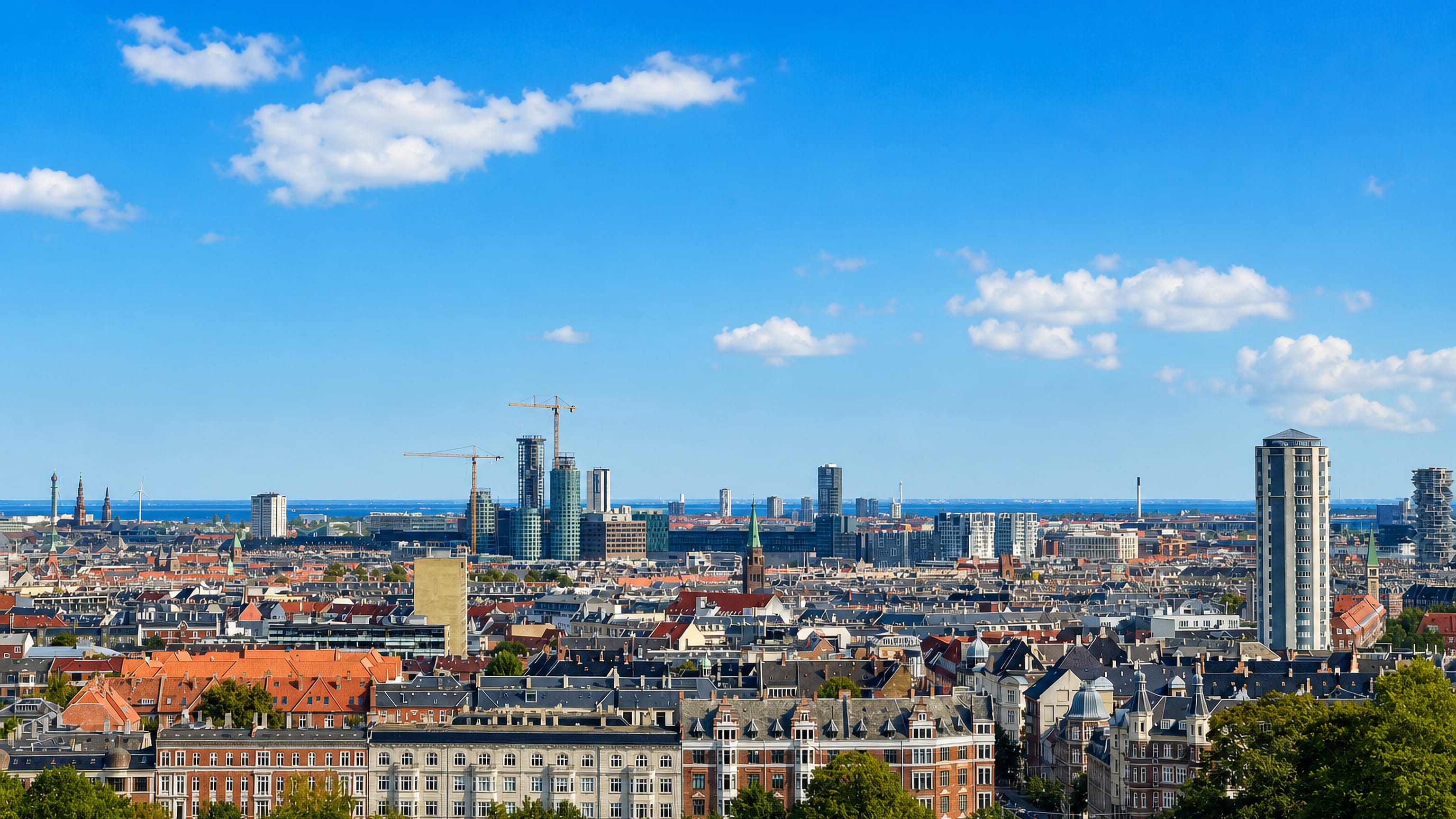 Rooftops and spires of Vesterbro, Copenhagen, stretching to the Oresund waterfront.