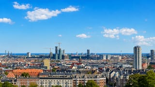 Rooftops and spires of Vesterbro, Copenhagen, stretching to the Oresund waterfront.