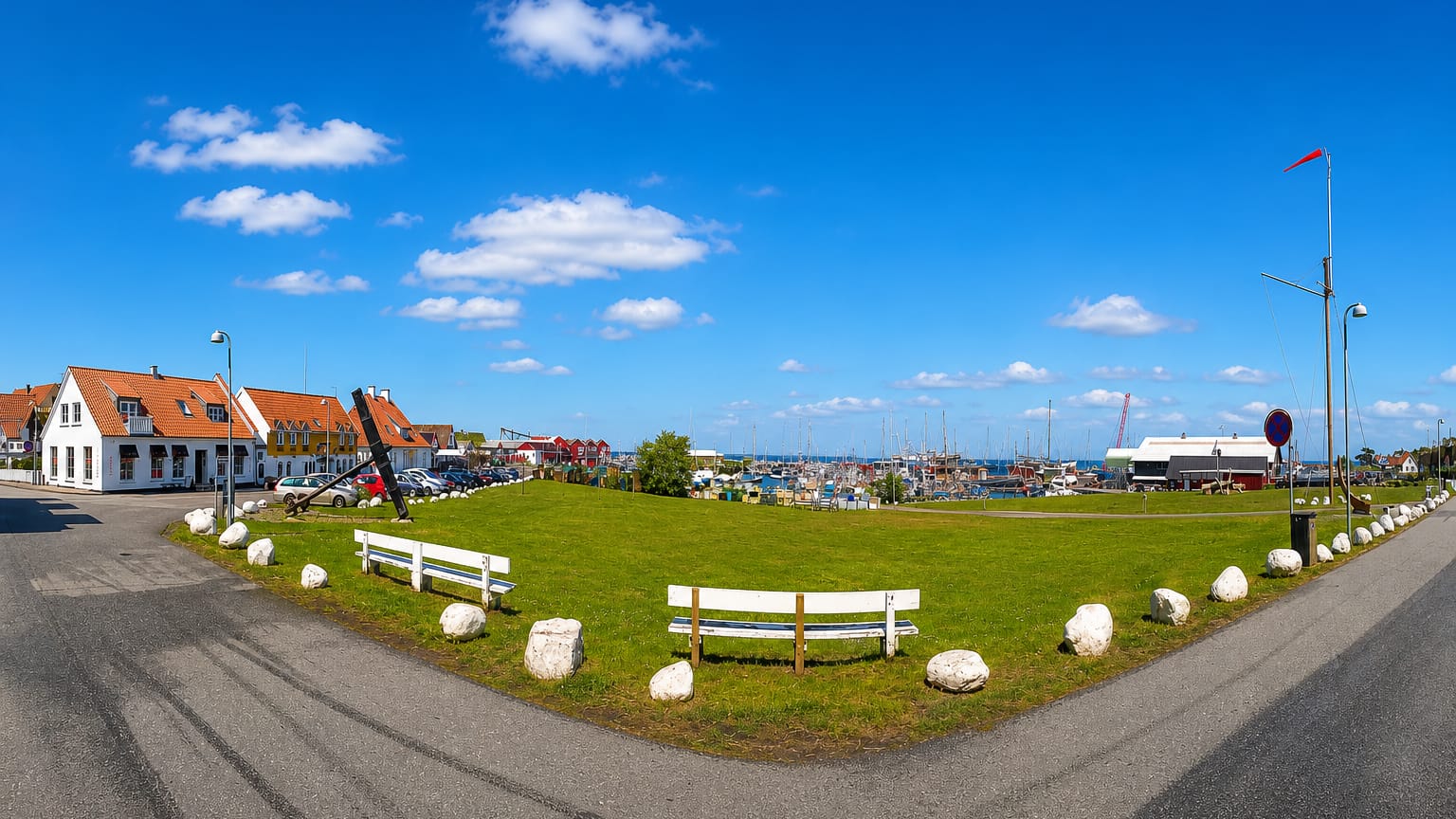 Waterfront green with an anchor monument and benches beside Gilleleje harbour and marina, Denmark