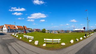 Waterfront green with an anchor monument and benches beside Gilleleje harbour and marina, Denmark