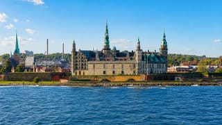 Kronborg Castle with its green copper spires seen across the Oresund water in Helsingor, Denmark.