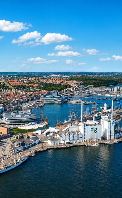 Aerial of Aarhus harbour and docklands with the DLG tower, old-town rooftops and cathedral spire
