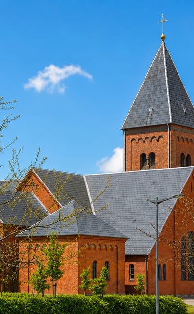 The red-brick church with its tall slate spire in Ikast, central Denmark.