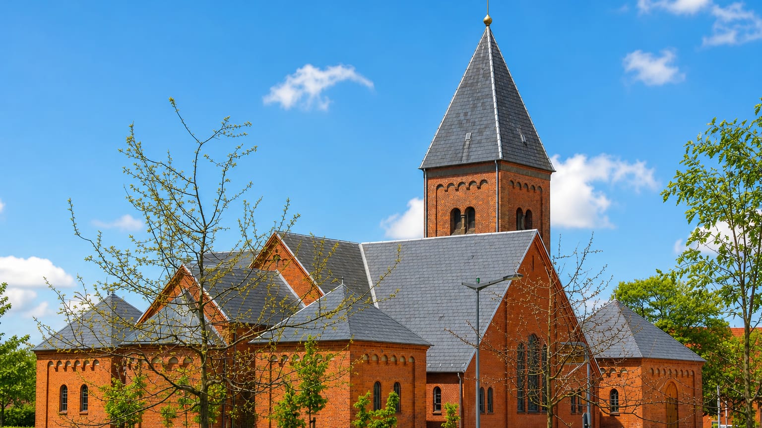 The red-brick church with its tall slate spire in Ikast, central Denmark.
