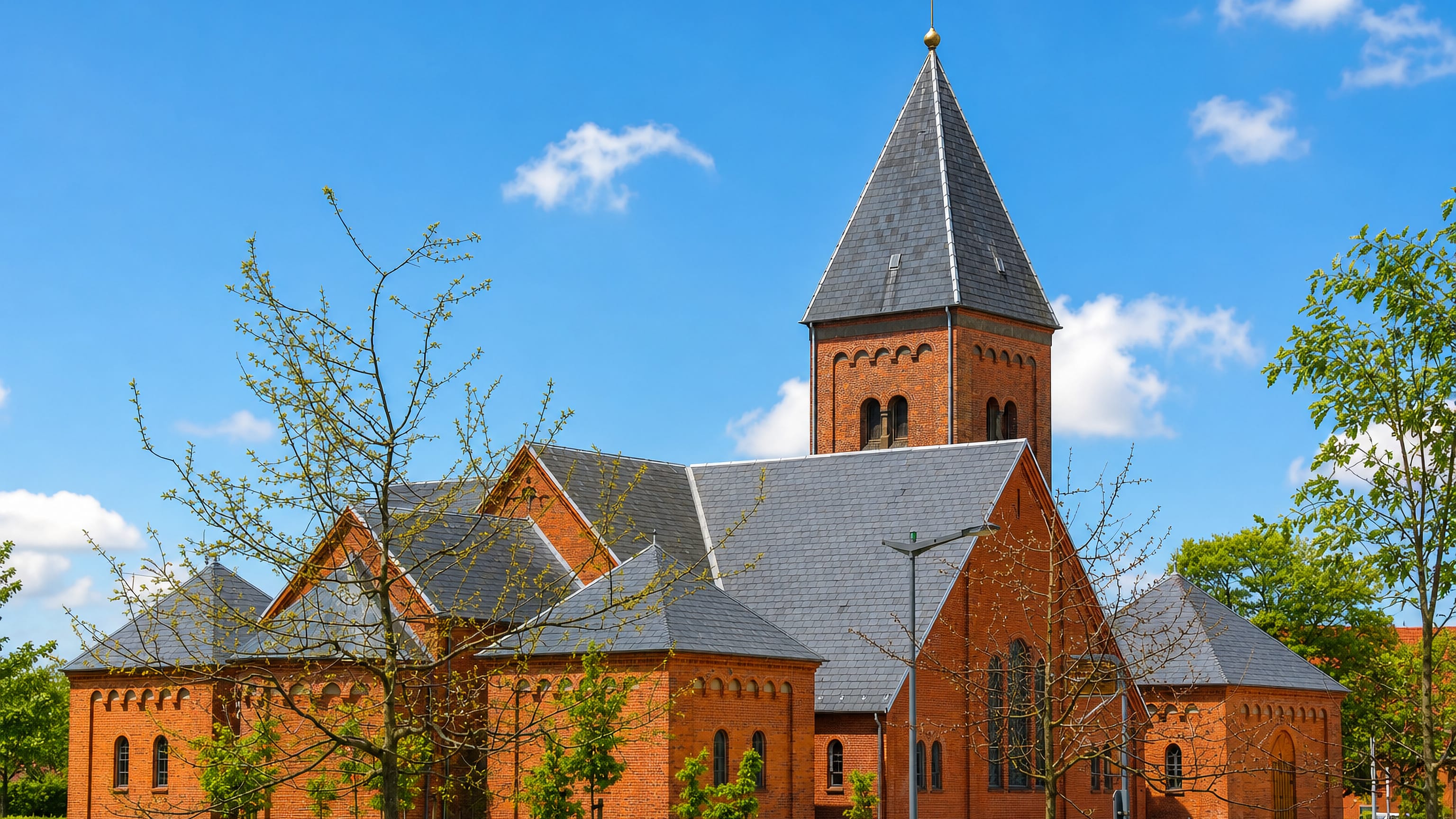 The red-brick church with its tall slate spire in Ikast, central Denmark.