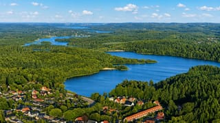 Aerial of Silkeborg town beside its forested lakes stretching into the Danish lake district