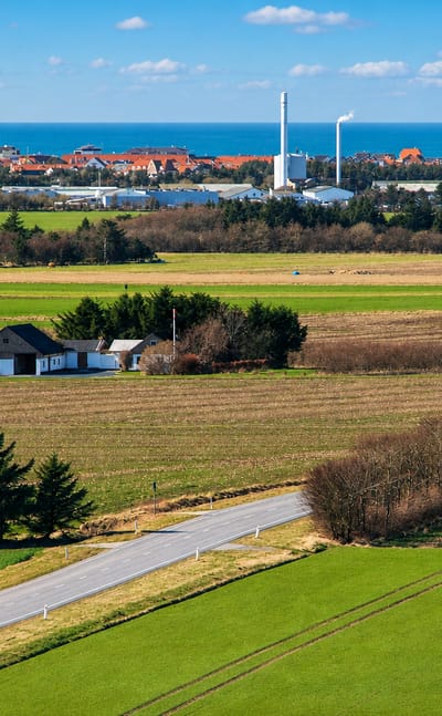Farmland with a country road leading toward Lokken's distant seaside skyline on the Danish coast.