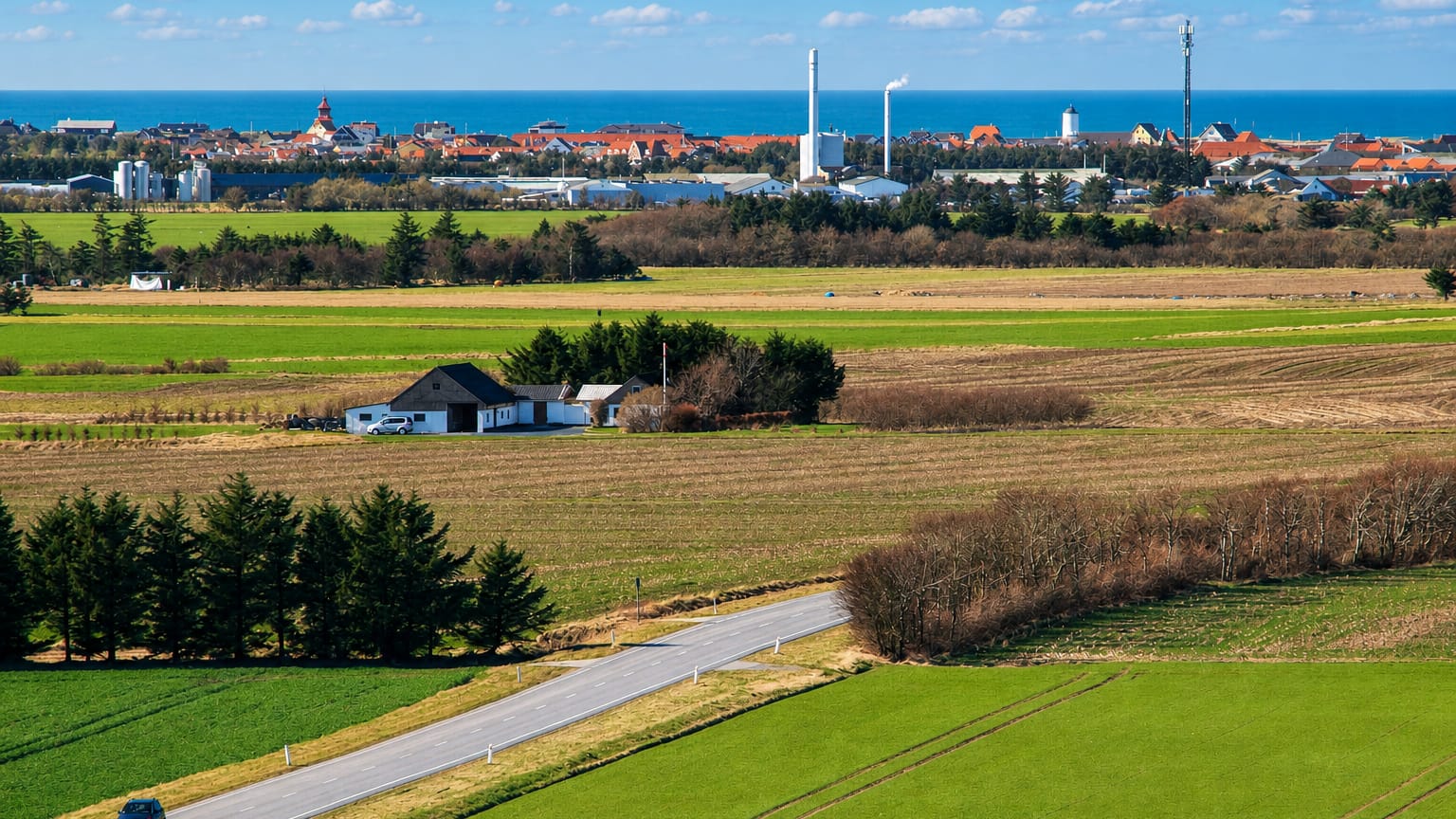 Farmland with a country road leading toward Lokken's distant seaside skyline on the Danish coast.