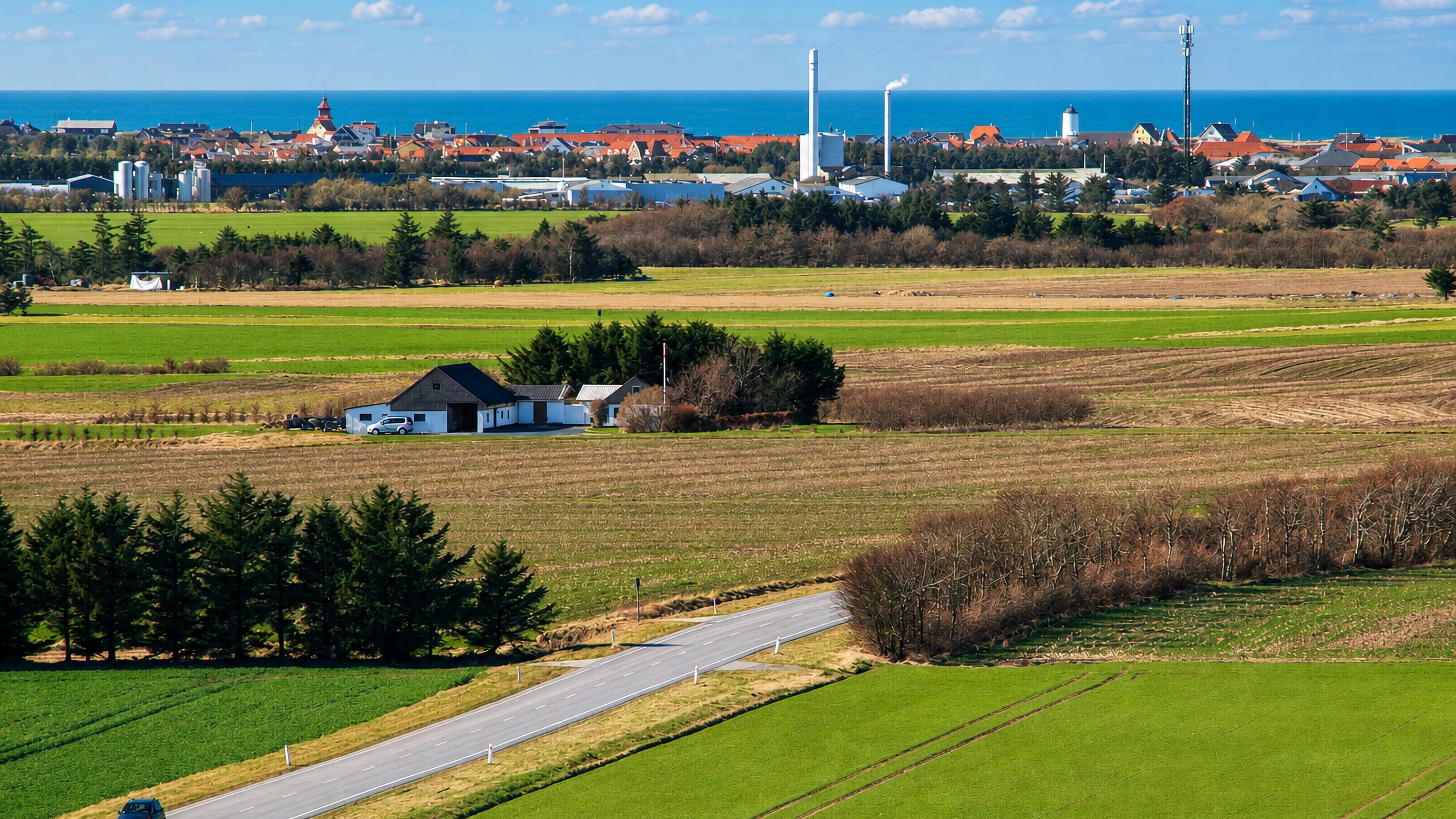 Farmland with a country road leading toward Lokken's distant seaside skyline on the Danish coast.