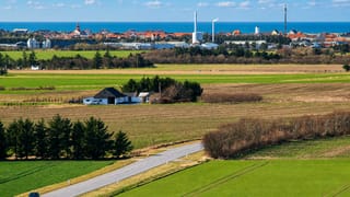 Farmland with a country road leading toward Lokken's distant seaside skyline on the Danish coast.