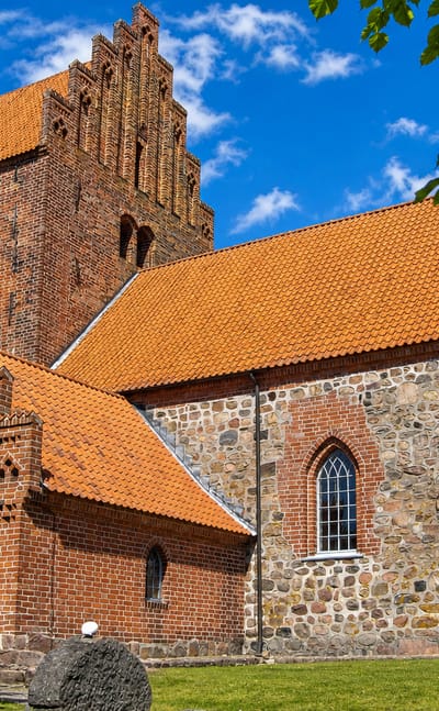 Medieval red-brick and fieldstone parish church with a stepped-gable tower at Højby on Zealand, Denmark.