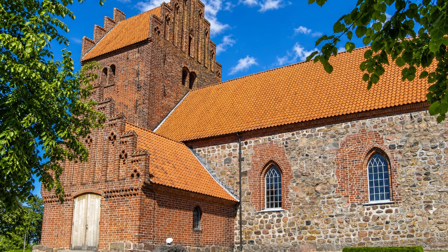Medieval red-brick and fieldstone parish church with a stepped-gable tower at Højby on Zealand, Denmark.