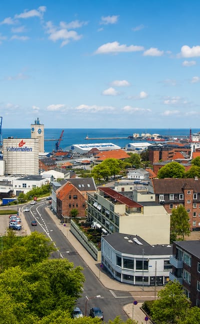 Aerial view of Esbjerg, Denmark, with the Valsemollen mill, harbour cranes and rooftops beside the North Sea.