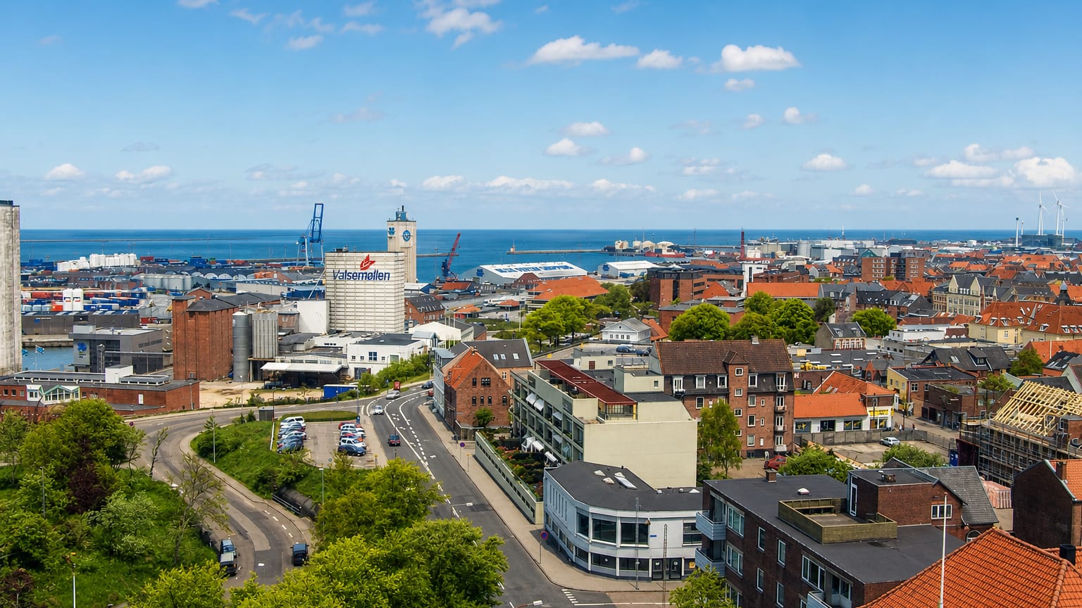 Aerial view of Esbjerg, Denmark, with the Valsemollen mill, harbour cranes and rooftops beside the North Sea.