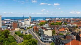 Aerial view of Esbjerg, Denmark, with the Valsemollen mill, harbour cranes and rooftops beside the North Sea.