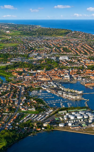 Aerial view of Nyborg, Denmark, showing its harbour marina, red-roofed old town and coastline by the sea.