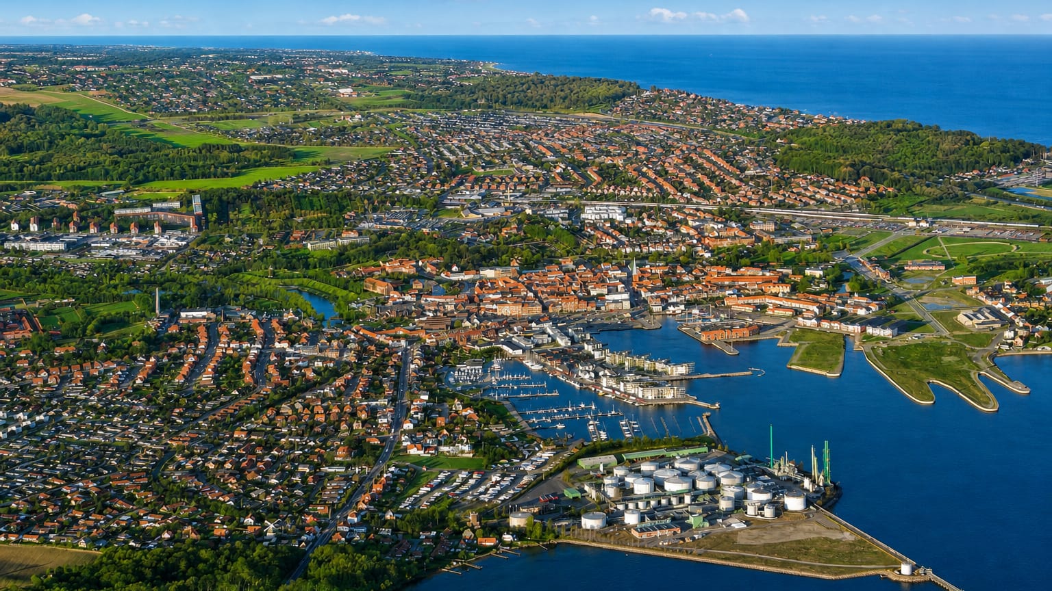 Aerial view of Nyborg, Denmark, showing its harbour marina, red-roofed old town and coastline by the sea.