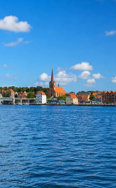 Sonderborg's waterfront with the Christian X pontoon bridge, church spire and old warehouses, Denmark