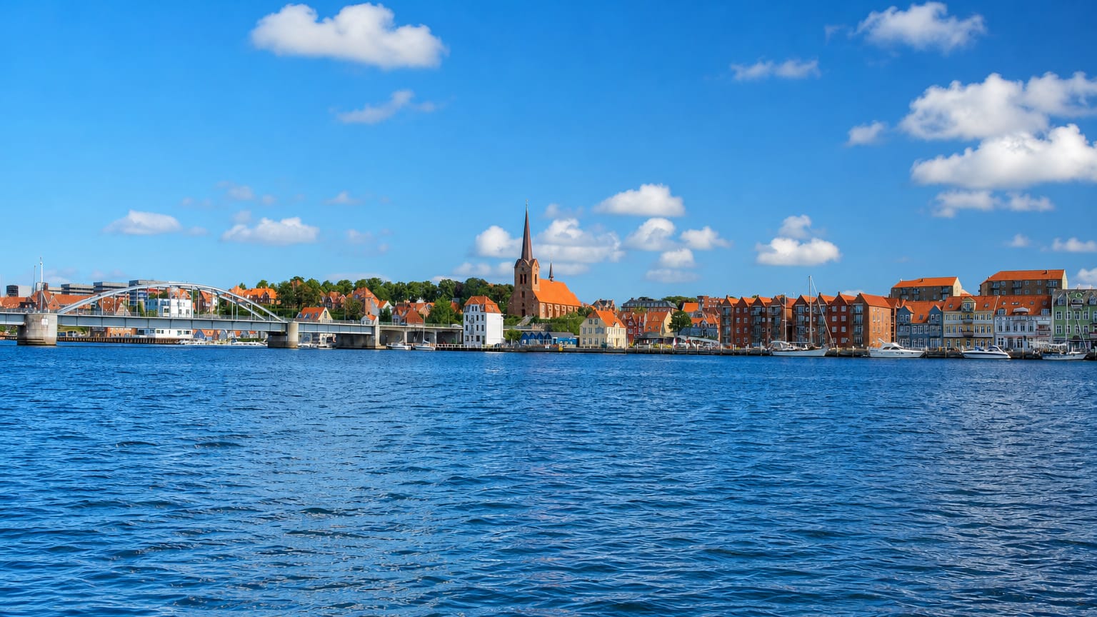 Sonderborg's waterfront with the Christian X pontoon bridge, church spire and old warehouses, Denmark